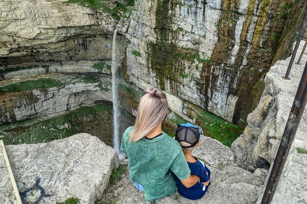 Uma menina com uma criança no fundo da cachoeira Tobot Khunzakh cachoeiras Daguestão Rússia 2021