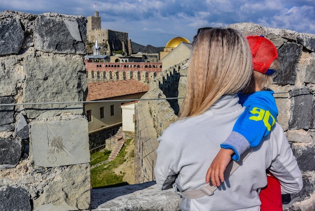 Uma menina com uma criança no fundo da fortaleza de Rabati em Akhaltsikhe Geórgia 2019