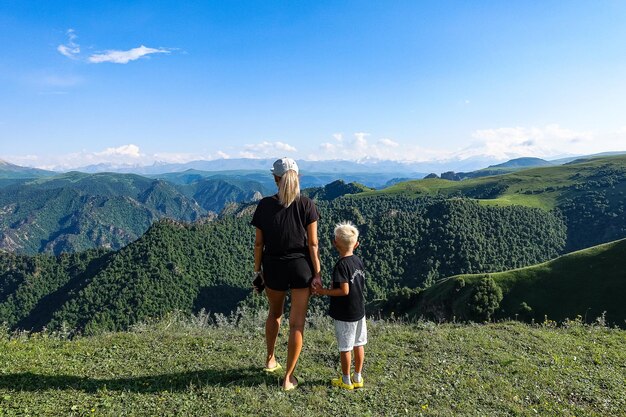 Uma menina com uma criança no fundo das montanhas do Cáucaso perto do trato de JilaSu KabardinoBalkaria