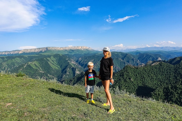 Uma menina com uma criança no fundo das montanhas do Cáucaso perto do trato de JilaSu KabardinoBalkaria