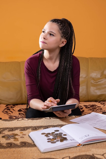 Foto uma menina conta suas finanças no final do mês porque agora é autônoma