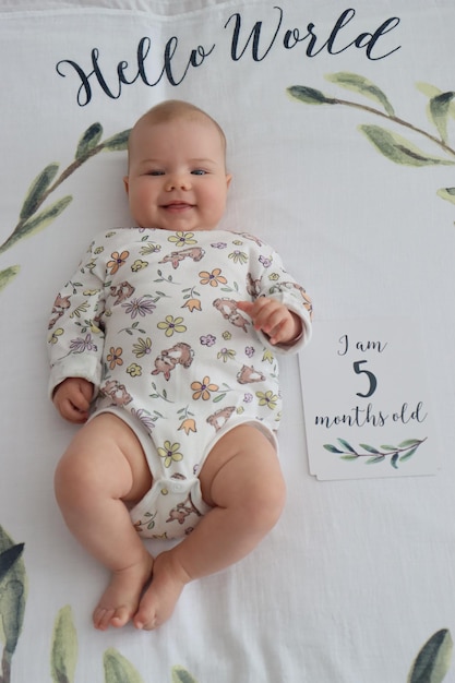 Uma menina de cinco meses, pura inocência em um cobertor rosa, irradia alegria nesta foto