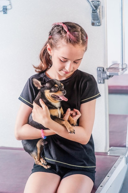 Uma menina de dez anos com um cachorro Chihuahua no trem Uma menina viaja com um cachorro