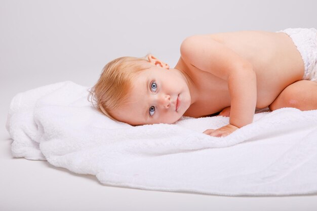 Uma menina de fralda encontra-se em um fundo branco