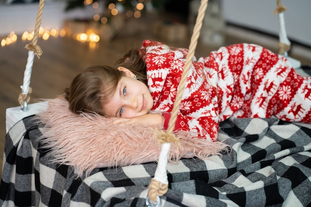 Uma menina de pijama não consegue dormir em uma noite festiva. Conto de fadas mágico de Natal. Infância feliz