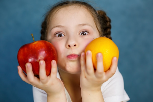 Uma menina de seis anos adora frutas. Vitaminas e alimentação saudável.