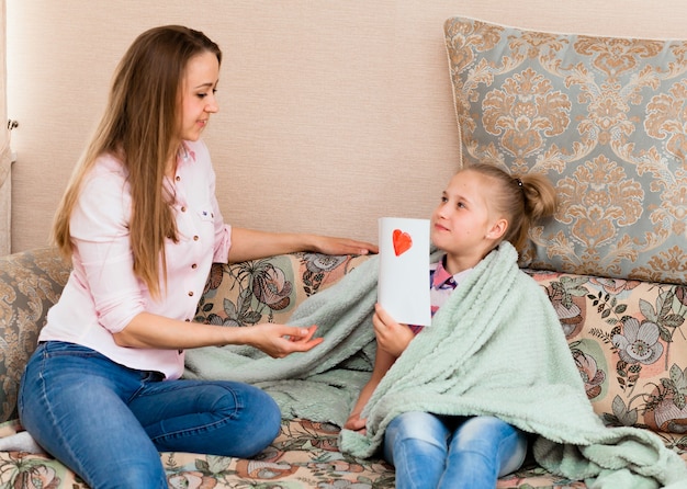 Uma menina desenha um cartão de felicitações para a mãe no dia das mães com as palavras 