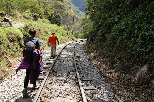 Uma menina e o guia fazendo a caminhada para Aguas Calientes