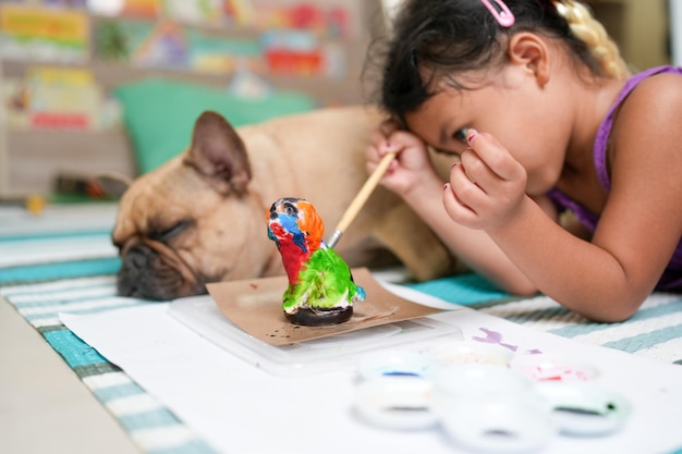 Uma menina e um cachorro estão pintando um peru.