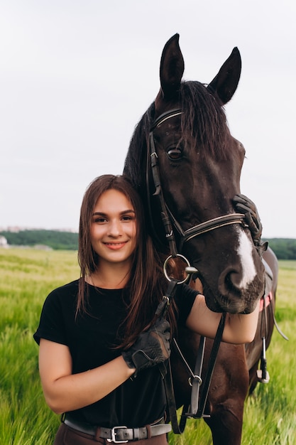 Uma menina e um jovem cavalo de esportes na natureza