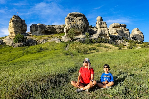 Uma menina e um menino no fundo de uma vista pitoresca das esfinges de Bakhchisarai Crimeia maio 2021