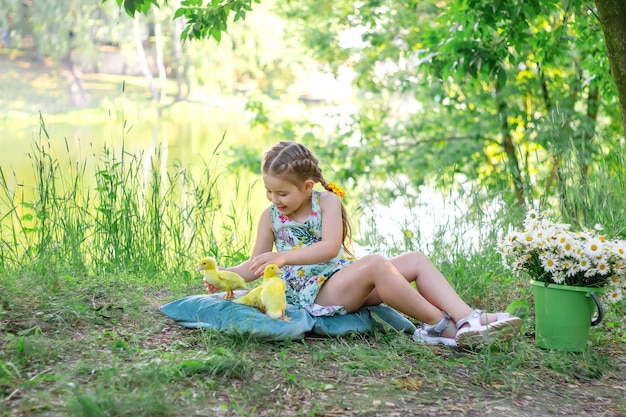 Uma menina e um patinho no verão ao ar livre gute bebês felicidade