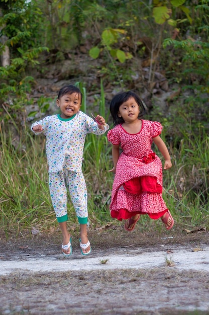 Uma menina e uma menina estão correndo na floresta.