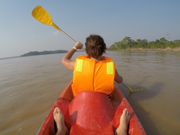 Uma menina em um passeio de canoa ao longo do rio Madre de Dios, em Puerto Maldonado, Peru