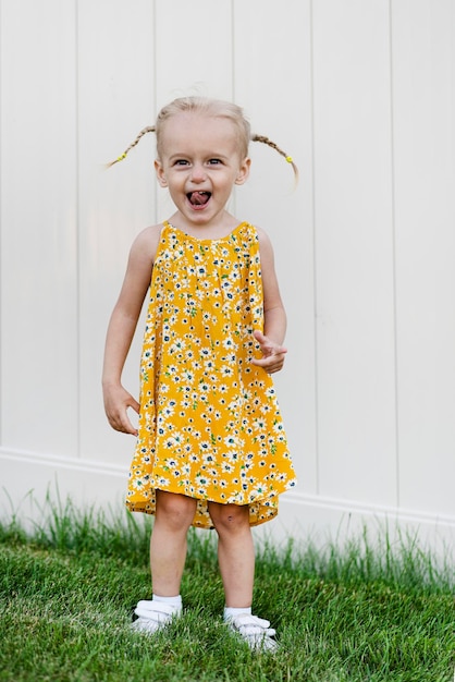 Foto uma menina em um vestido amarelo com flores nele
