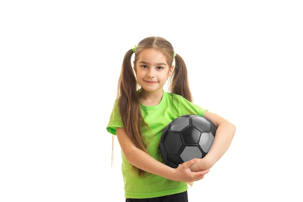 uma menina encantadora segurando uma bola de futebol isolada no fundo branco