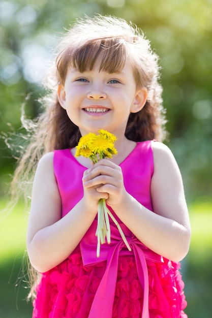 Uma menina está segurando um buquê de flores.