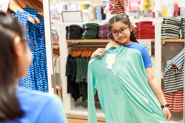 Foto uma menina experimentou roupas em frente ao espelho em um shopping