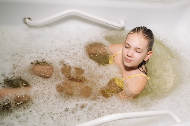 Uma menina faz o procedimento em um banho mineral. O paciente recebe tratamentos de água com banho mineral de pérolas