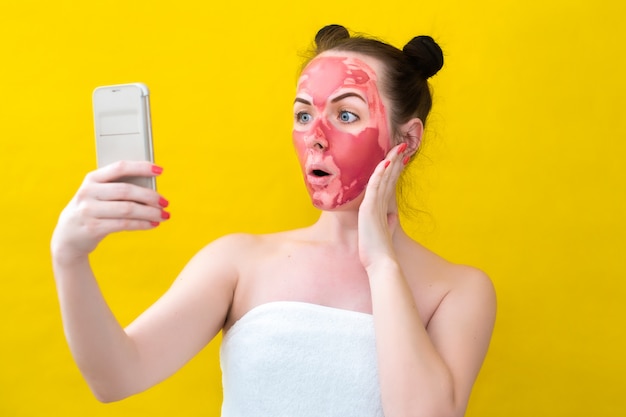 Uma menina faz tratamentos de spa com uma máscara no rosto