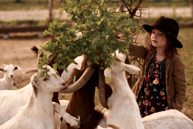 Uma menina gosta de estar em uma fazenda com animais.