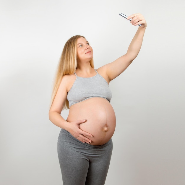 Uma menina grávida detém um smartphone com informações úteis sobre o parto