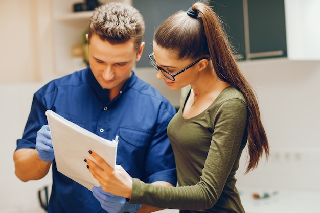 Uma menina jovem e bonita consulta com um dentista no consultório do dentista