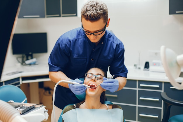 Uma menina jovem e bonita trata seus dentes com um dentista