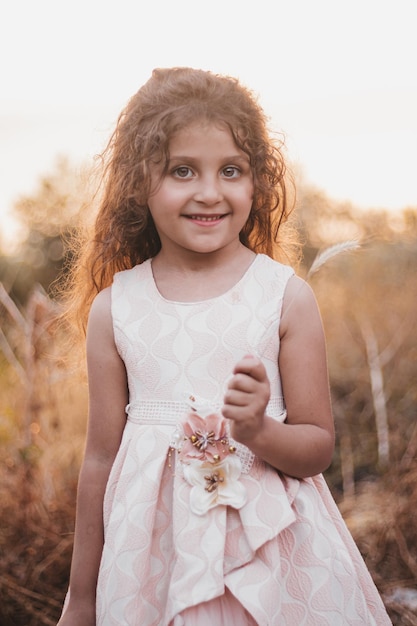 Uma menina num campo durante um pôr-do-sol