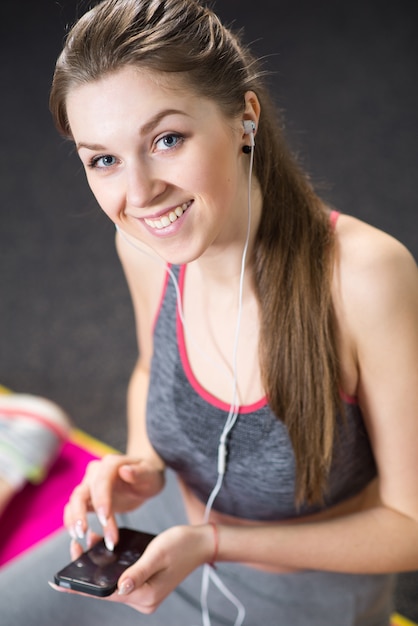 Uma menina ouvindo música após o treino no ginásio