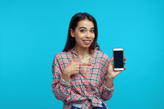 Uma menina recomenda o dispositivo ou app aponta para a tela de maquete do smartphone