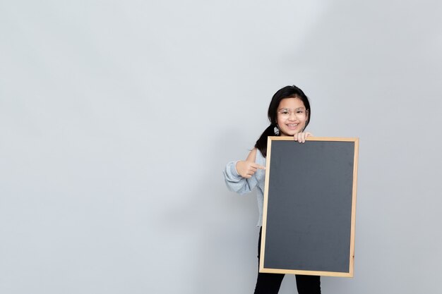 Uma menina segurando um quadro-negro em branco