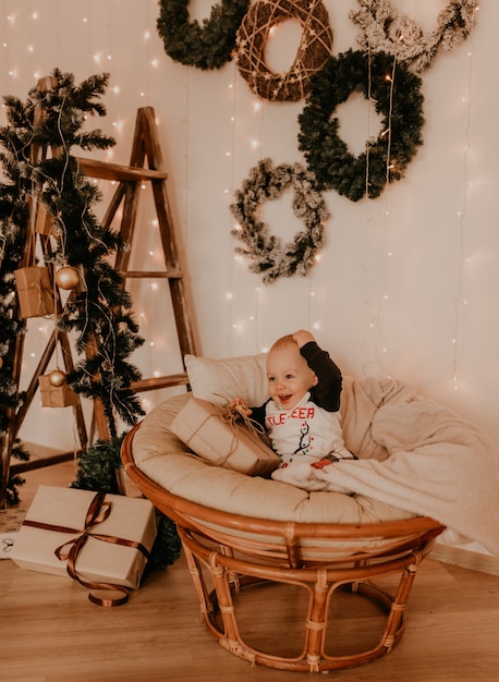 Uma menina sentada na cadeira e brincando. manha de natal. interior de ano novo. celebração do dia dos namorados