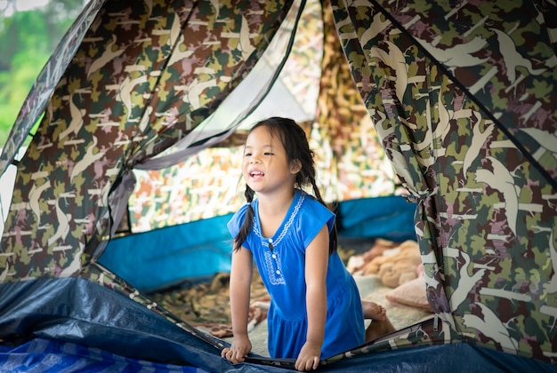 Uma menina sentada na tenda, indo acampar