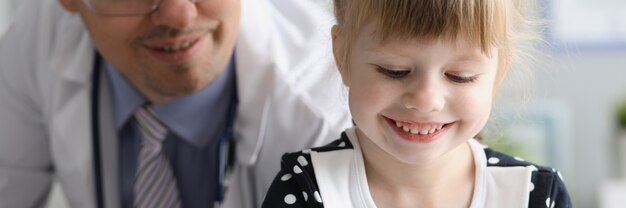 Uma menina sentada na visita do médico na clínica