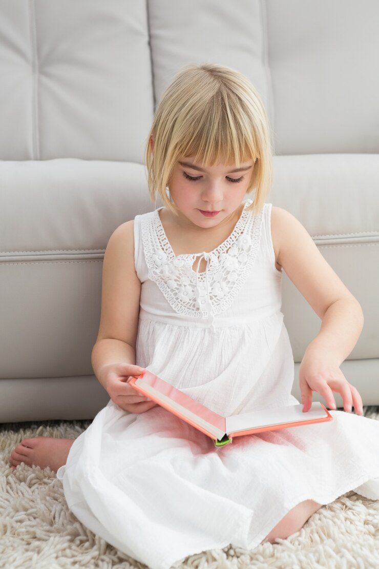 Foto uma menina sentada no chão lendo livro de histórias