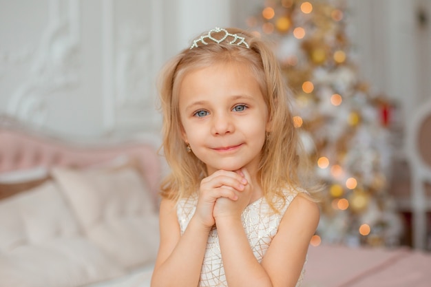 Uma menina sonha perto da árvore de Natal em casa