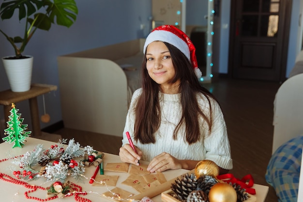 uma menina sorridente com um chapéu de Natal faz um calendário do advento