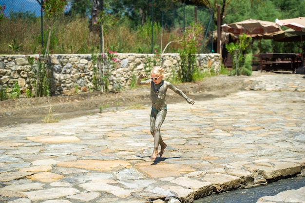 Uma menina suja corre pela rua perto de fontes curativas na Turquia