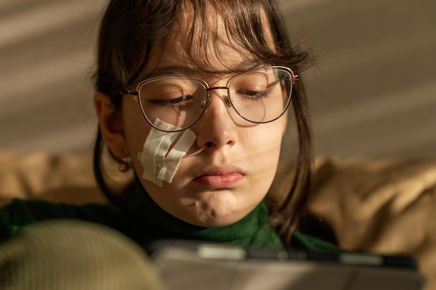 Uma menina tem um cateter saindo do nariz após uma punção do seio maxilar