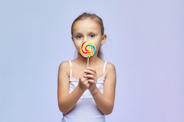 Foto uma menina tem um grande doce nas mãos.