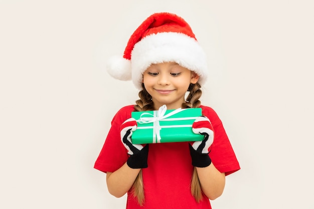 Uma menina tem um presente nas mãos para o Natal.