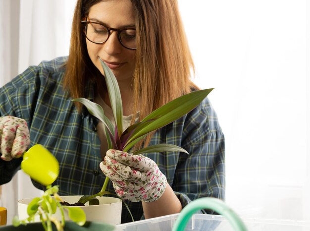 Foto uma menina transplanta uma flor de casa para uma nova florista de pote grande no trabalho com plantas de casa no apartamento