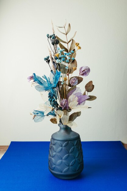 Uma mesa azul com um vaso com flores