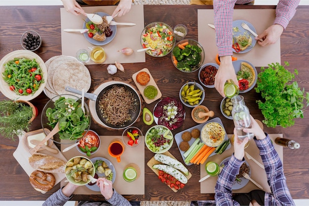 Uma mesa cheia de comida, incluindo uma tigela de salada e uma tigela de salada.