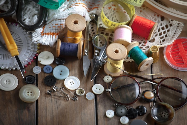 Uma mesa cheia de materiais de costura, incluindo botões, tesouras e uma fita métrica.