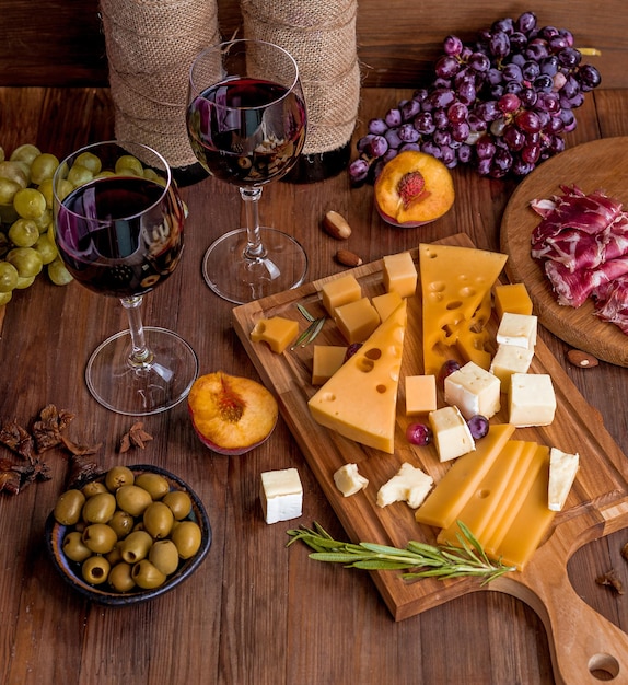 Uma mesa com taças de queijo e vinho e uma garrafa de vinho.