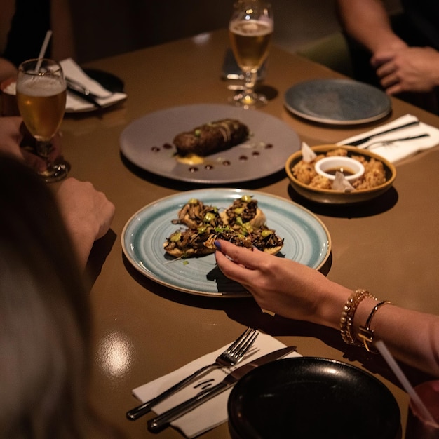 Uma mesa com um prato de comida e um copo de cerveja