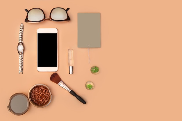 Uma mesa com um telefone, uma tigela de feijão, uma tigela de maquiagem, uma xícara de café, uma tigela de maquiagem, uma tigela de maquiagem e um par de óculos.