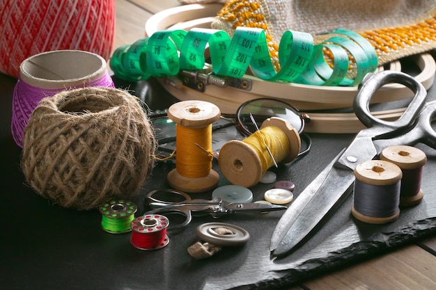 Foto uma mesa com uma máquina de costura, uma fita verde, uma tesoura, uma agulha e uma tesoura.